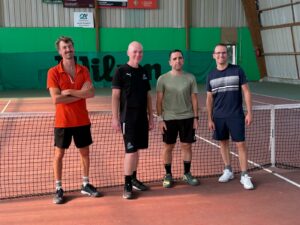 Les quatre joueurs de l’Équipe 4 Hommes +35 ans du Tennis Club de Questembert au filet du court couvert